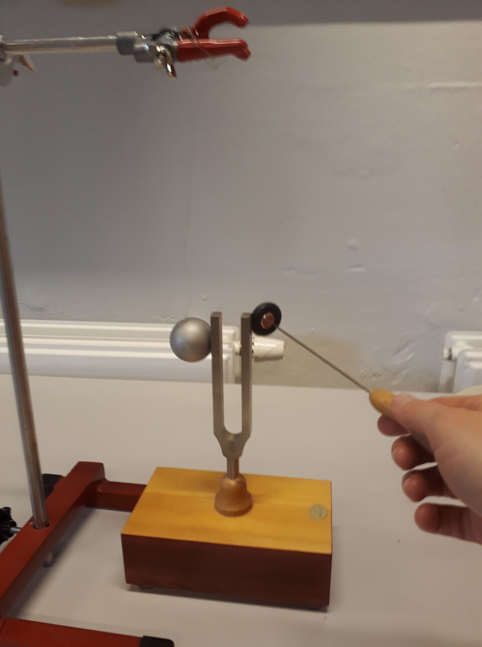 Bilde 2: Stemmegaffel med bordtennisball inntil en av tindene. Når man slår på stemmegaffelen, vil ballen vibrere mot gaffelen.